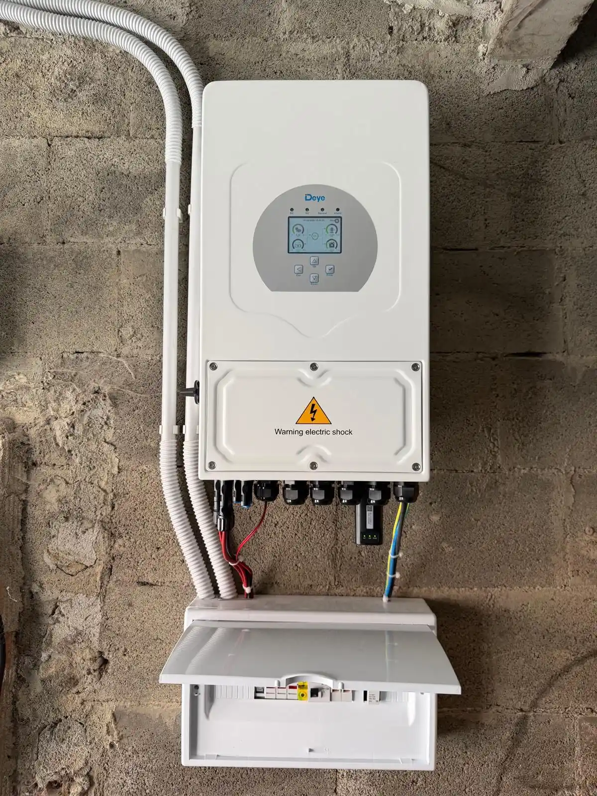 Instalación de paneles fotovoltaicos con inversor híbrido blanco y cableado protegido en Getafe