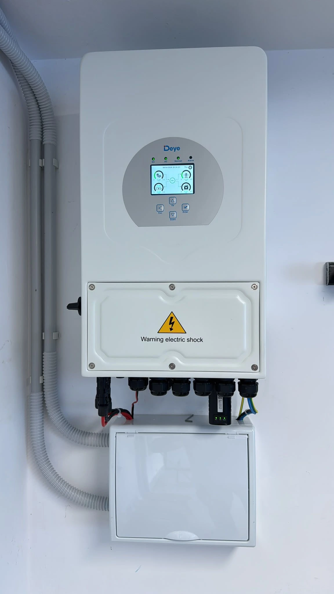 Instalación de paneles fotovoltaicos con inversor híbrido blanco y cableado protegido en Getafe